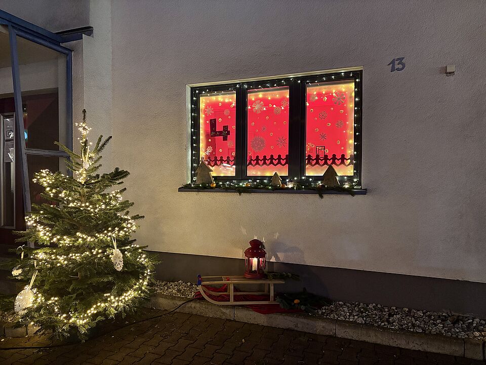 2936 Das vom ATZ gestaltete Adventsfenster zum 4 Dezember, mit einem Weihnachtsbaum davor.